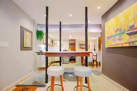 Apartamento para alugar com 110m², 2 quartos e 1 vaga Apartamento para alugar com 110m², 2 quartos e 1 vagaSala com mesa e duas cadeiras, com pintura de barcos no fundo.