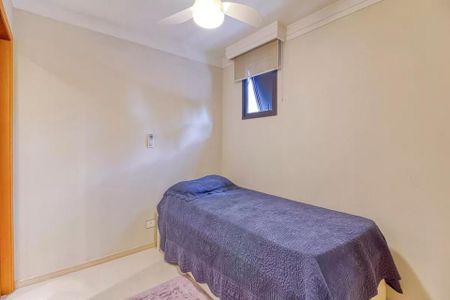 Quarto pequeno com cama simples e paredes brancas, iluminado por uma lâmpada de teto. de apartamento à venda com 4 quartos, 115m² em Indianópolis, São Paulo