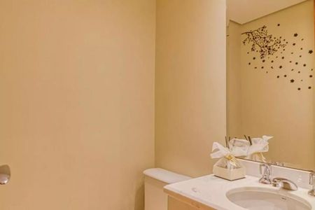 Banheiro com pia branca e espelho com decoração de árvore de flores. de apartamento à venda com 4 quartos, 115m² em Indianópolis, São Paulo