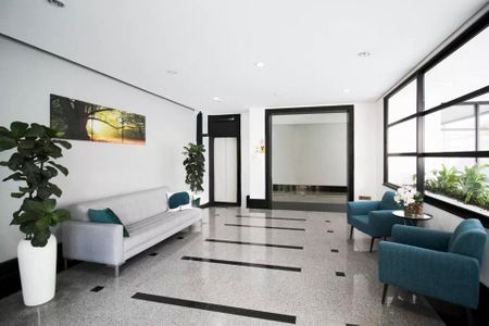 Sala de espera com sofá e cadeiras, iluminada por janelas e com um quadro na parede. de apartamento à venda com 4 quartos, 115m² em Indianópolis, São Paulo
