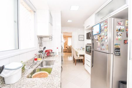Cozinha com móveis brancos e azuis, pia e fogão vermelhos, e uma geladeira com fotos na porta. de apartamento à venda com 4 quartos, 117m² em Vila Sonia, São Paulo