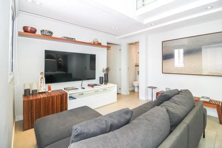 Sala de estar com sofá, TV e mesa de centro, decorada com objetos de arte e decoração. de apartamento à venda com 4 quartos, 200m² em Vila Romana, São Paulo
