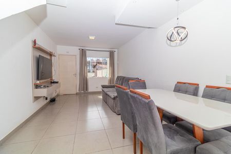 Sala de estar com sofá e mesa de jantar, iluminada por lâmpada de design moderno. de casa à venda com 4 quartos, 97m² em Jardim Cláudia, São Paulo