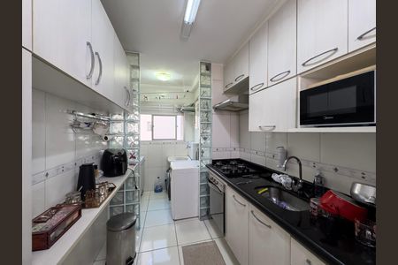 Cozinha com móveis brancos e azuis, iluminada por luzes brancas, com um micro-ondas e uma geladeira, e uma janela grande. de apartamento à venda com 3 quartos, 59m² em Vila Bela, São Paulo