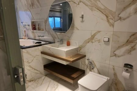 Banheiro com piso de porcelanato, vaso sanitário e lavabo branco, espelho redondo e iluminação adequada. de casa à venda com 4 quartos, 287m² em Vila America, São Paulo