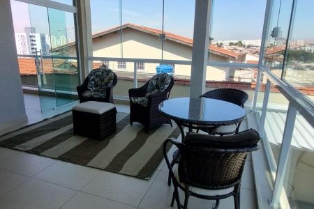 Varanda com vista para a cidade, com móveis de wicker e mesa de vidro. de casa à venda com 4 quartos, 287m² em Vila America, São Paulo