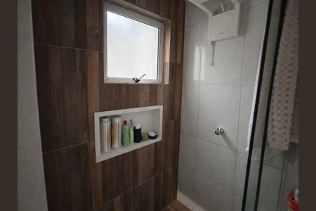 Banheiro com piso de porcelanato e parede de madeira, com uma janela pequena e iluminação boa. de casa à venda com 4 quartos, 128m² em Vila Londrina, São Paulo