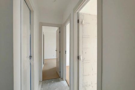 Corredor com portas e paredes brancas, com um chão de concreto e um piso de madeira no final. de apartamento à venda com 3 quartos, 69m² em Santo Cristo, Rio de Janeiro